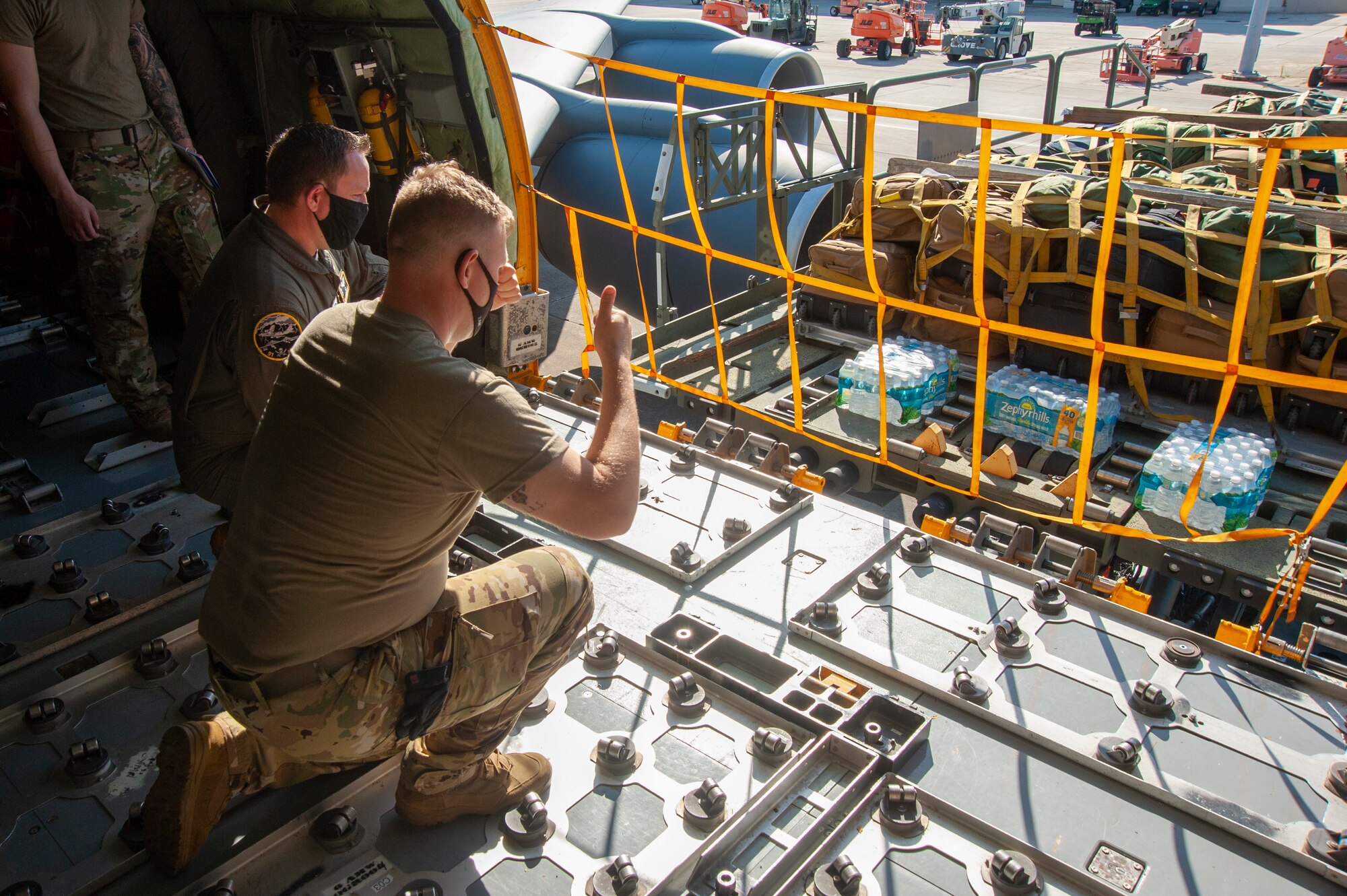 U.S. Air Force Airman 1st Class Tristan Shannon, a 91st Air Refueling Squadron (ARS) boom operator, signals to the K-Loader driver when pulling up to a KC-135 Stratotanker on the flightline, April 9, 2021, at MacDill Air Force Base, Fla. The K-Loader loaded bags belonging to Airmen from the 91st ARS that deployed to Al Udeid Air Base, Qatar. (U.S. Air Force photo by Airman 1st Class David D. McLoney)