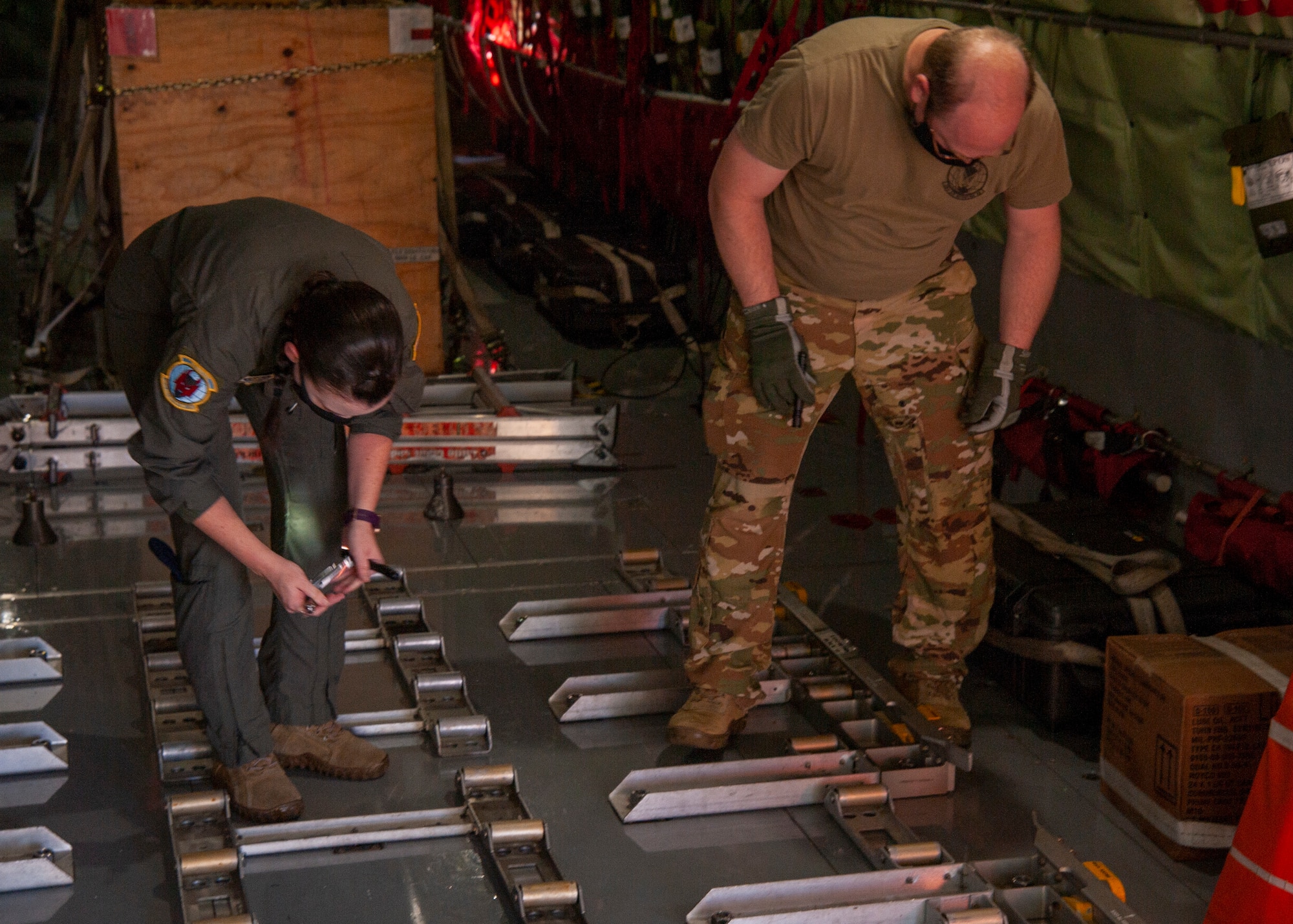 U.S. Air Force Senior Airman Ashley Upton (left), a 50th Air Refueling Squadron (ARS) boom operator, and Tech. Sgt. Kris Schools (right), a 50th ARS instructor boom operator, inspect the mounting hardware for the cargo roller wheels on a KC-135 Stratotanker aircraft at MacDill Air Force Base, Fla., April 9, 2021, prior to a 91st ARS deployment. Airmen from the 50th ARS completed pre-deployment measures for deploying 91st ARS Airmen to help reduce the burden of certain preparations before the 91st flew to their deployed location.  (U.S. Air Force photo by Airman 1st Class David D. McLoney)