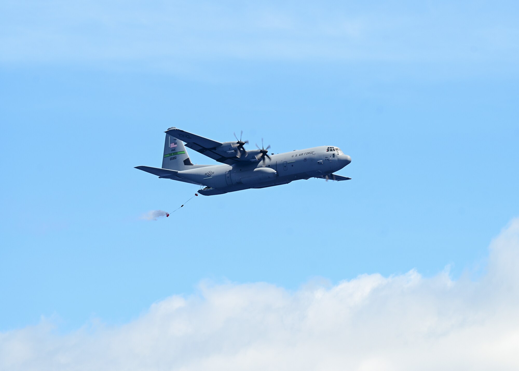 A bundle is dropped from the back of an aircraft