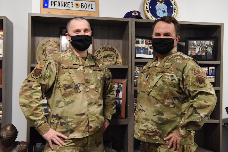 Two men in uniform pose for the camera.