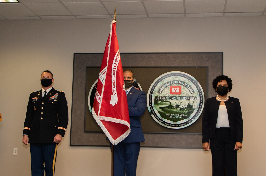 U.S. Army Corps of Engineers (USACE) Vicksburg District Commander Col. Robert Hilliard (left), Vicksburg District Leadership Development Program member Wesley Miller, and Deputy District Engineer Pat Hemphill present the USACE Vicksburg District’s new flag during an uncasing ceremony March 29.