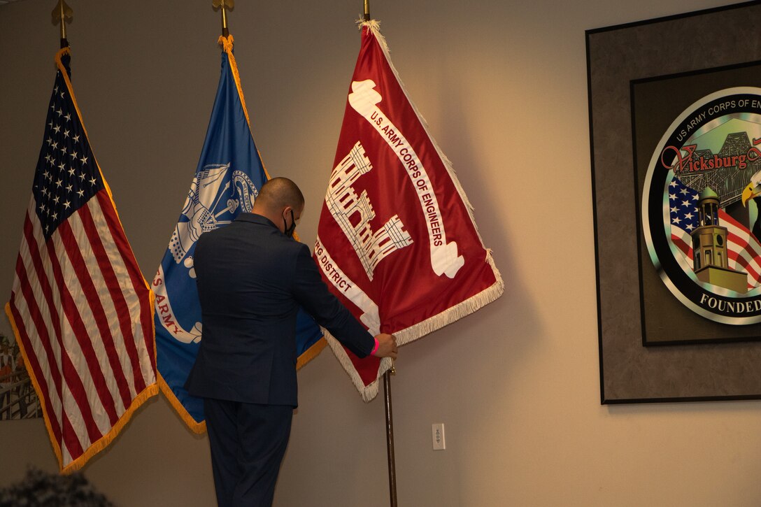 Vicksburg District Leadership Development Program member Wesley Miller displays the USACE Vicksburg District’s new flag during an uncasing ceremony March 29.