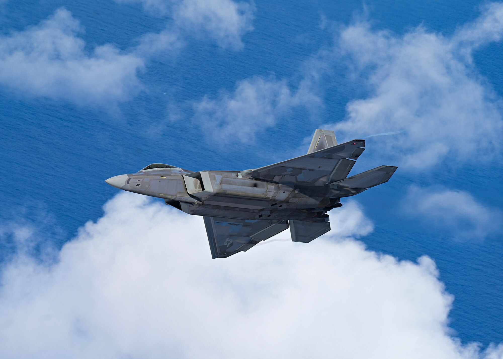 A fighter aircraft flies over Hawaii.