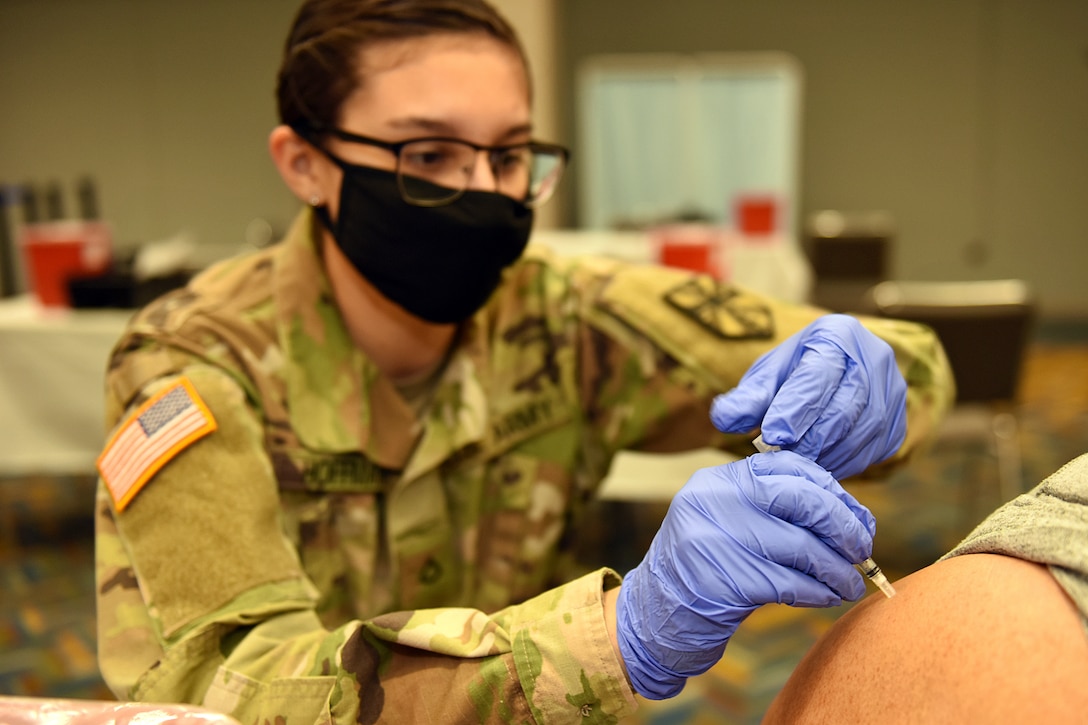 Michigan National Guard Soldiers with Michigan’s Task Force Red Lion COVID-19 Vaccination/Testing Team help the Detroit Health Department vaccinate residents during a vaccination clinic at TCF Center, Detroit, Michigan, April 6, 2021.