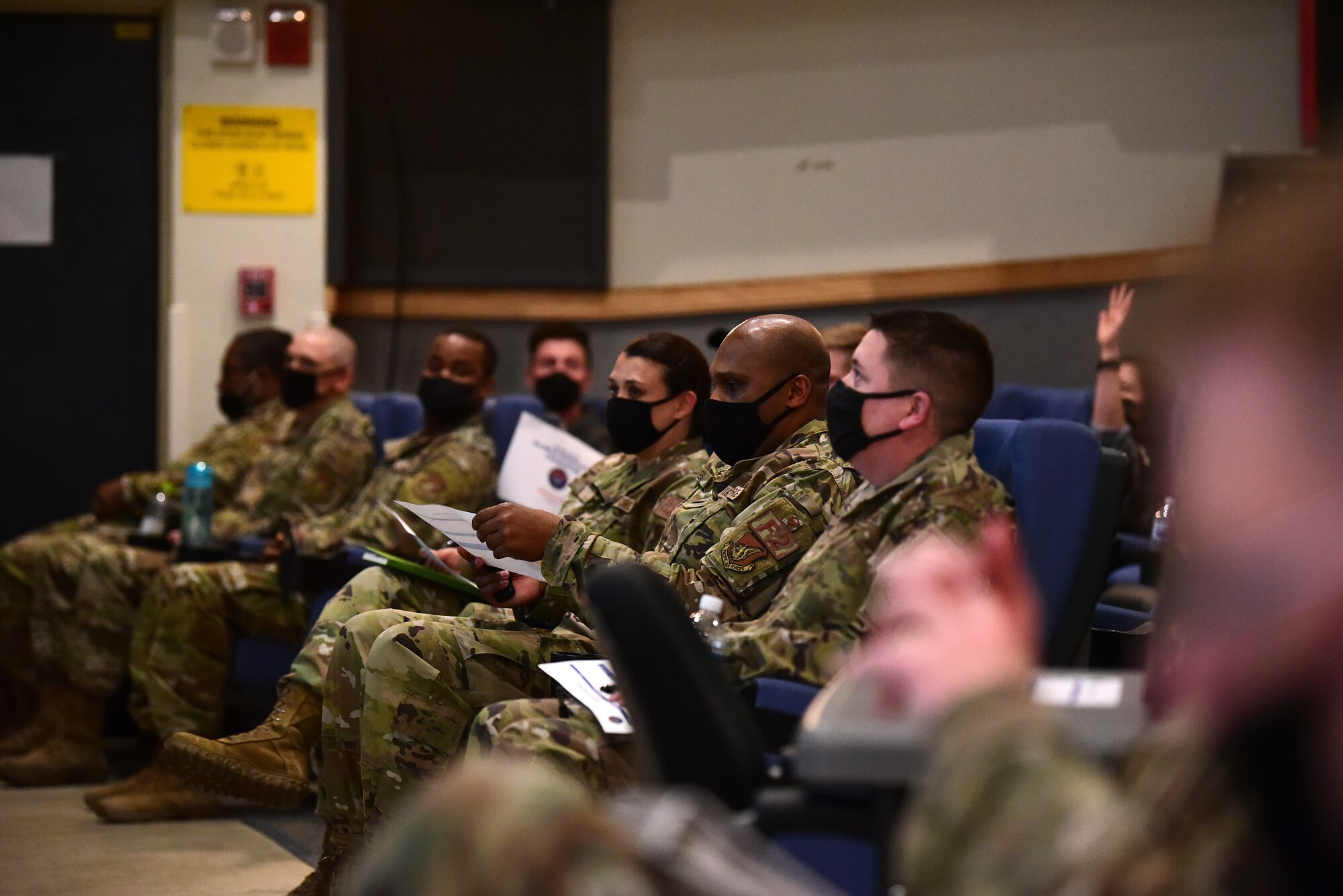 Audience members listen to a presentation during a Wolf Tank at Kunsan Air Base, Republic of Korea, April 9, 2021. Wing leadership funded three of the five ideas that were presented, which included a wireless intercom system, an inner ear bone conducting headset, and hardened aircraft system GPS repeaters. (U.S. Air Force photo by Senior Airman Suzie Plotnikov)