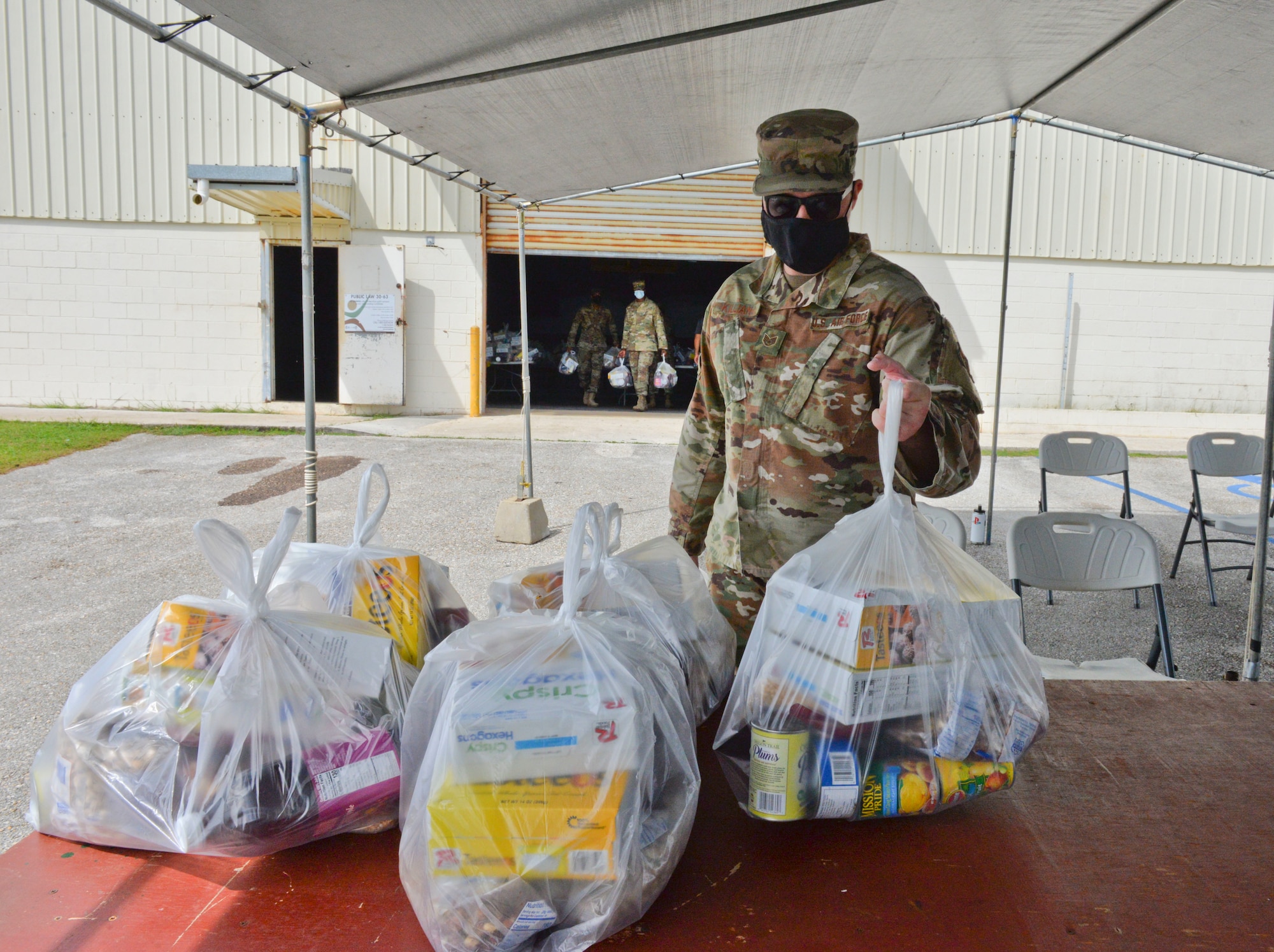 U.S. Air Force Staff Sgt. Nicholas Killian, 36th Civil Engineering Squadron workforce manager, places food commodities onto a table in preparation for a COVID-19 relief food distribution event at the community gym in Yona, Guam, April 15, 2021. The 36th CES is Yona’s sister squadron, as part of the Andersen Air Force Base Sister Village Sister Squadron program, through which squadron members collaborate with Guam residents in activities to strengthen their friendship and partnership. (U.S. Air Force photo by Alana Chargualaf)