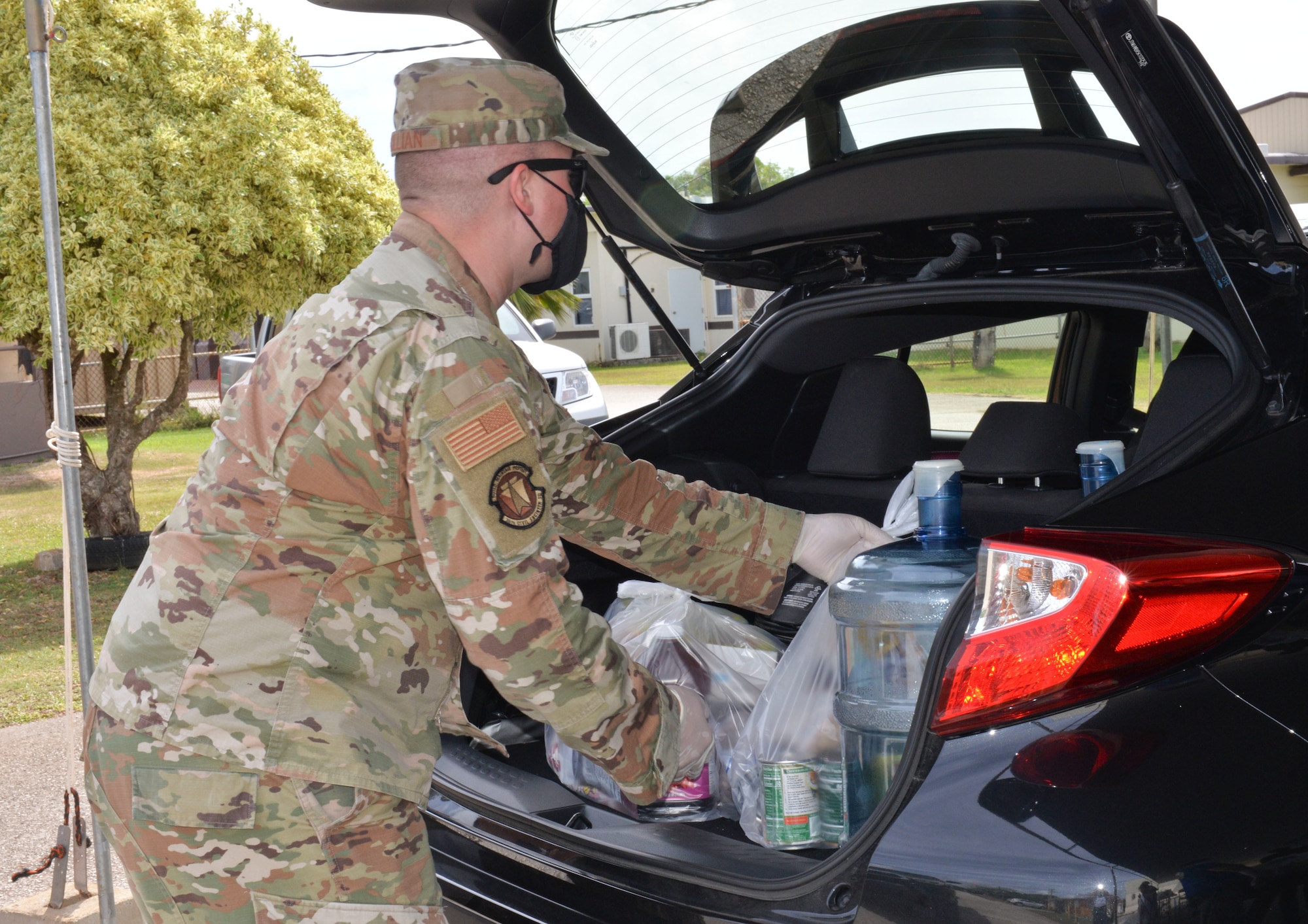 U.S. Air Force Staff Sgt. Nicholas Killian, 36th Civil Engineering Squadron workforce manager, loads bags of food commodities into a village resident’s vehicle during a COVID-19 relief food distribution event at the community gym in Yona, Guam, April 15, 2021. The 36th CES is Yona’s sister squadron, as part of the Andersen Air Force Base Sister Village Sister Squadron program, through which squadron members collaborate with Guam residents in activities to strengthen their friendship and partnership. (U.S. Air Force photo by Alana Chargualaf)