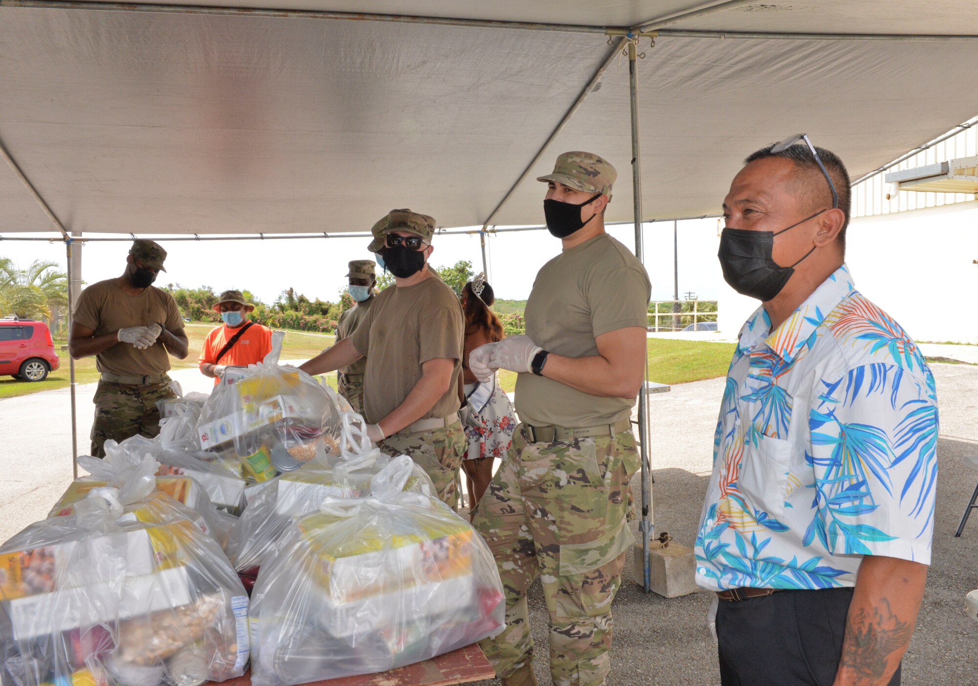 U.S. Air Force Airmen assigned to the 36th Civil Engineering Squadron and Kylani Ogo, Miss Voluptuous Pacific and Yona resident, participate a COVID-19 relief food distribution event at the community gym in Yona, Guam, April 15, 2021. The 36th CES is Yona’s sister squadron, as part of the Andersen Air Force Base Sister Village Sister Squadron program, through which squadron members collaborate with Guam residents in activities to strengthen their friendship and partnership. (U.S. Air Force photo by Alana Chargualaf)