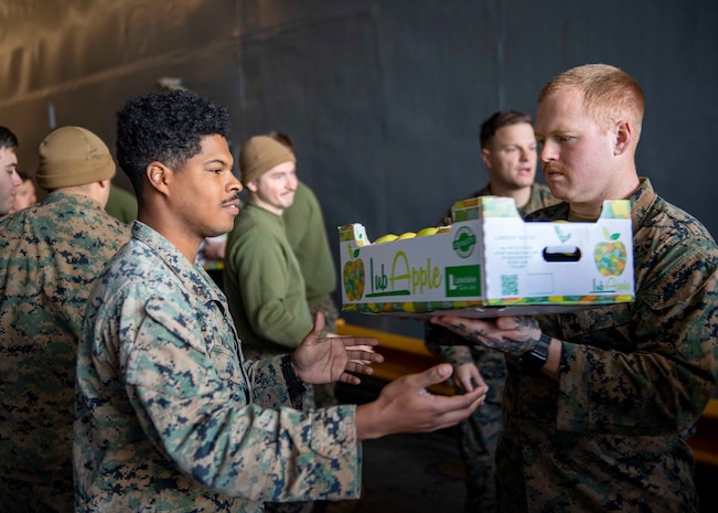 Hospital Corpsman 3rd Class Jameel Alston, left, and Hospital Corpsman Seaman Logan Vincent, both assigned to the 24th Marine Expeditionary (24th MEU), move supplies aboard the Harpers Ferry-class dock landing ship USS Carter Hall (LSD 50) during a replenishment-at-sea, April 12, 2021.