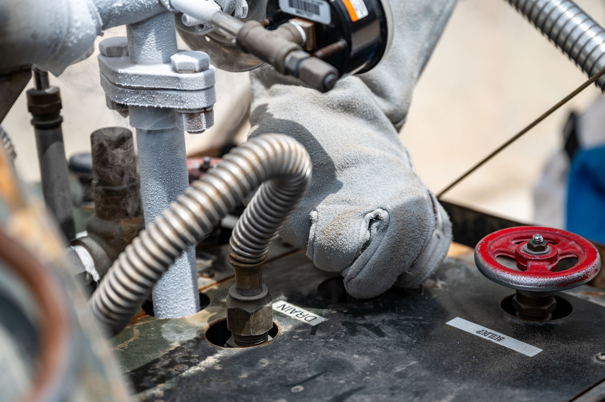 Senior Airman Steven C. Rehana drains liquid oxygen to collect a sample.