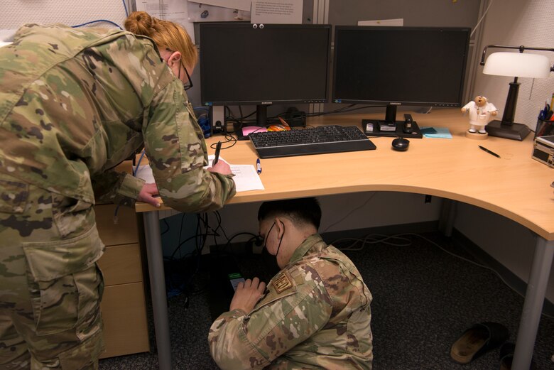 U.S. Air Force Tech. Sgt. Kaci Stephens, 86th Medical Support Squadron medical information services flight client support noncommissioned officer in charge, left, and Senior Airman Henry Diaz Casado, medical information services technician, swap out computer stations within the dental clinic at Ramstein Air Base, Germany, April 6, 2021