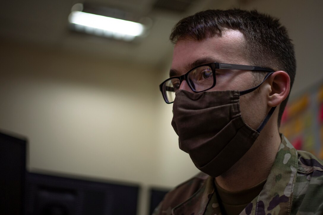 A photo of an Airman looking at a computer