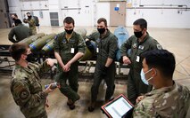 Airmen from the 340th Weapons Squadron receives instruction from Senior Airman Chad McCannon, bottom left, 548th Combat Training Squadron munitions liasion, during a training bomb build at Barksdale Air Force Base, Louisiana, April 13, 2021. Airmen from the 340th WPS integrated with the 2nd Munitions Squadron to teach the students the components and procedures that go into assembling a bomb. (U.S. Air Force photo by Airman 1st Class Jacob B. Wrightsman)