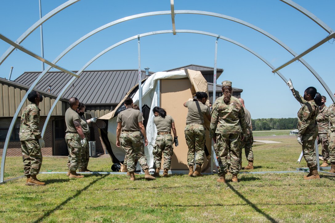 Reserve Citizen Airmen of the 913th Force Support Squadron organize the canvas material around the entryway of an Alaska tent during the 4-day unit training assembly, April 8, 2021, a Little Rock Air Force Base, Arkansas. The tent is commonly used during deployments and the training was one of many sessions that took place to ensure personnel are ready to deploy and operate in dynamic, austere environments. (U.S. Air Force photo by Senior Airman Kalee Sexton)
