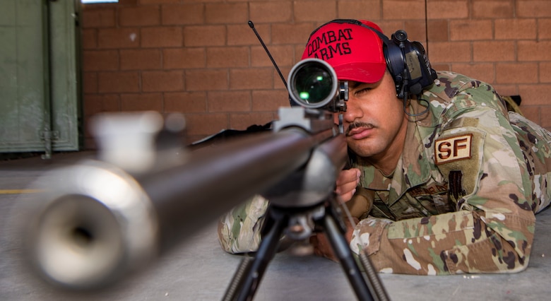 Airman looks though sniper rifle scope.