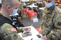 Pennsylvania National Guard members prepare a dose of the COVID-19 vaccine for community members at the Esperanza Community Vaccine Center in Philadelphia on April 13, 2021.