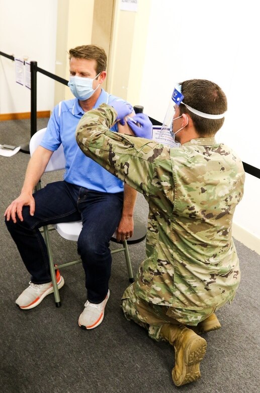 Spc. Ryan Whispell, a combat medic with the 328th Brigade Support Battalion, 56th Stryker Brigade Combat Team, 28th Infantry Division, Pennsylvania Army National Guard, provides a COVID-19 vaccine to Brian Sherman, a local community member, April 14 in Lancaster, Pa.