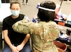 Spc. Adom Yaa, a combat medic with the 103rd Brigade Engineer Battalion, 56th Stryker Brigade Combat Team, 28th Infantry Division, Pennsylvania Army National Guard, administers the COVID-19 vaccine to Brittany Gill, a local resident, Apr. 14 in Lancaster, Pa.