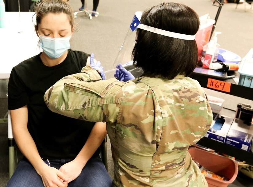 Spc. Adom Yaa, a combat medic with the 103rd Brigade Engineer Battalion, 56th Stryker Brigade Combat Team, 28th Infantry Division, Pennsylvania Army National Guard, administers the COVID-19 vaccine to Brittany Gill, a local resident, Apr. 14 in Lancaster, Pa.