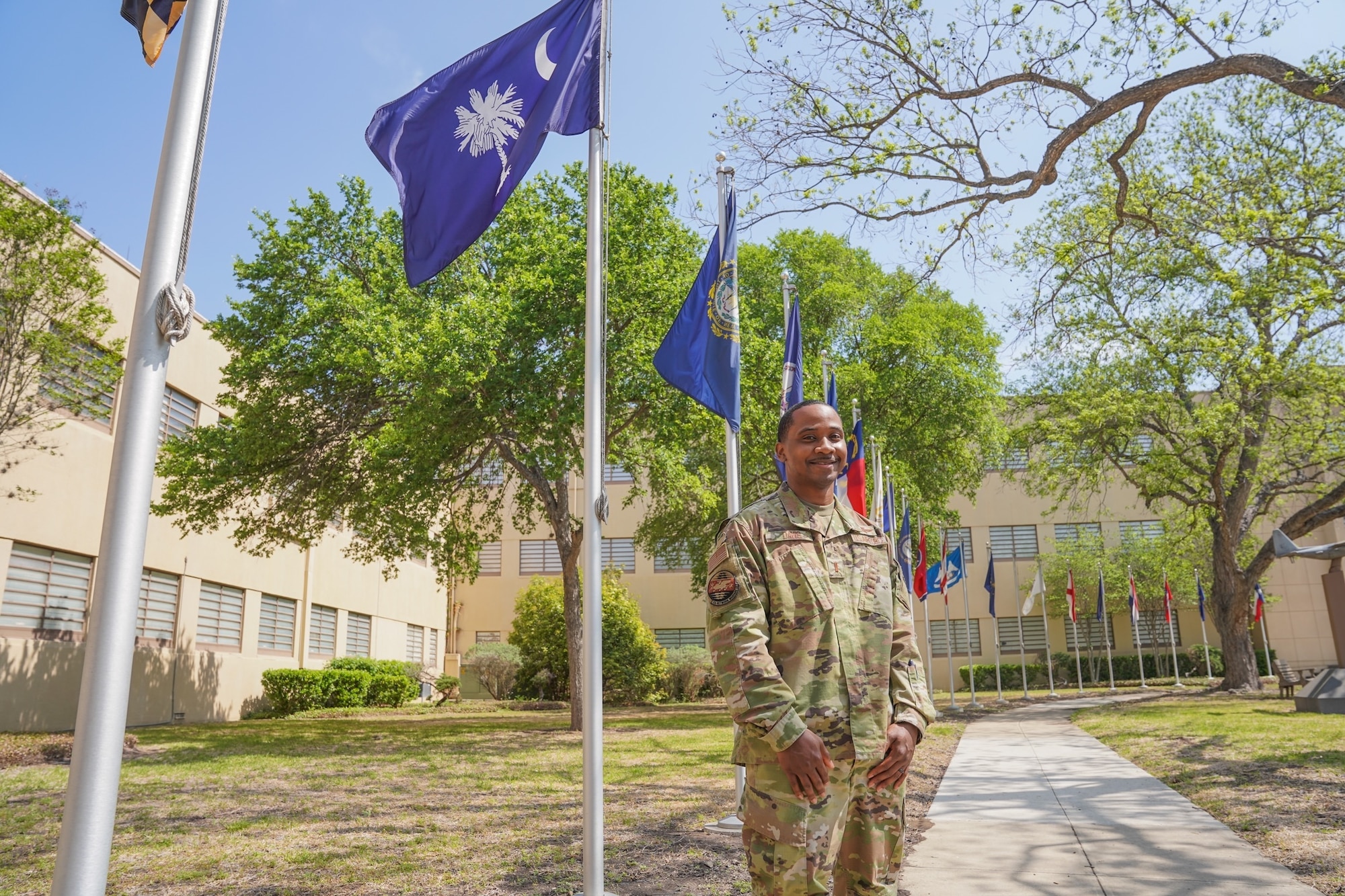 Male Airman stands in front of building wearing U.S. Air Force uniform.