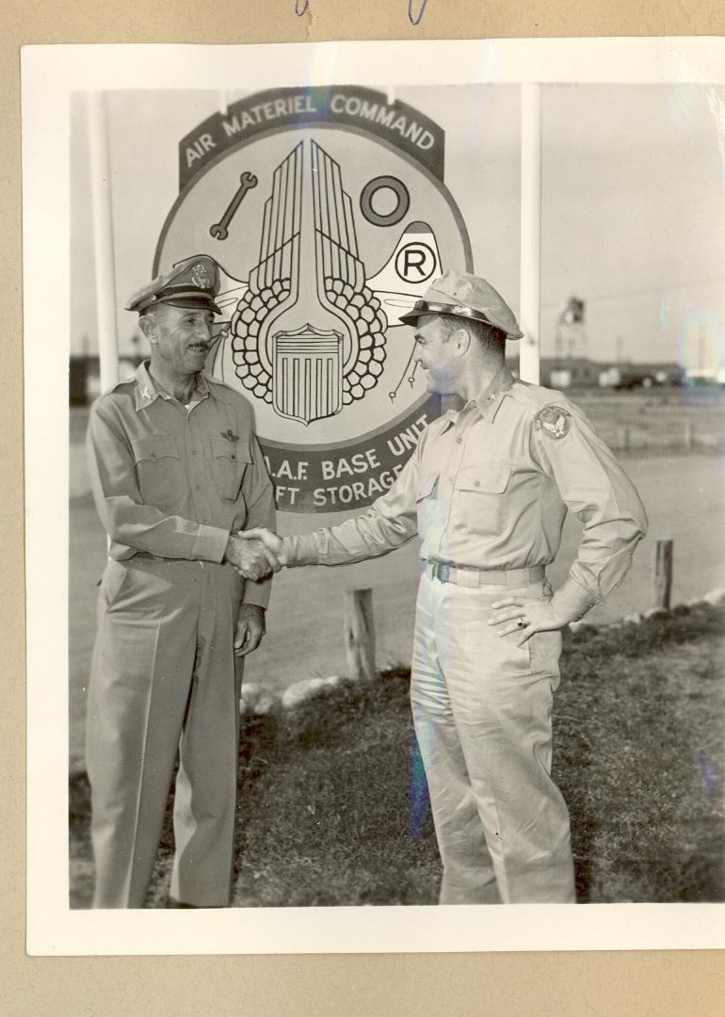 A black and white photo of two Airmen shaking hands.