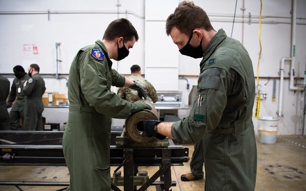 Capts. Samuel Shrewsberry and Michael McBrien, 340th Weapons Squadron weapons instructor course students, inspect training munitions during a training bomb build at Barksdale Air Force Base, Louisiana, April 13, 2021. The Airmen from the 340th WPS trained with the 2nd Munitions Squadron to better learn and understand what it takes to build munitions. (U.S. Air Force photo by Airman 1st Class Jacob B. Wrightsman)