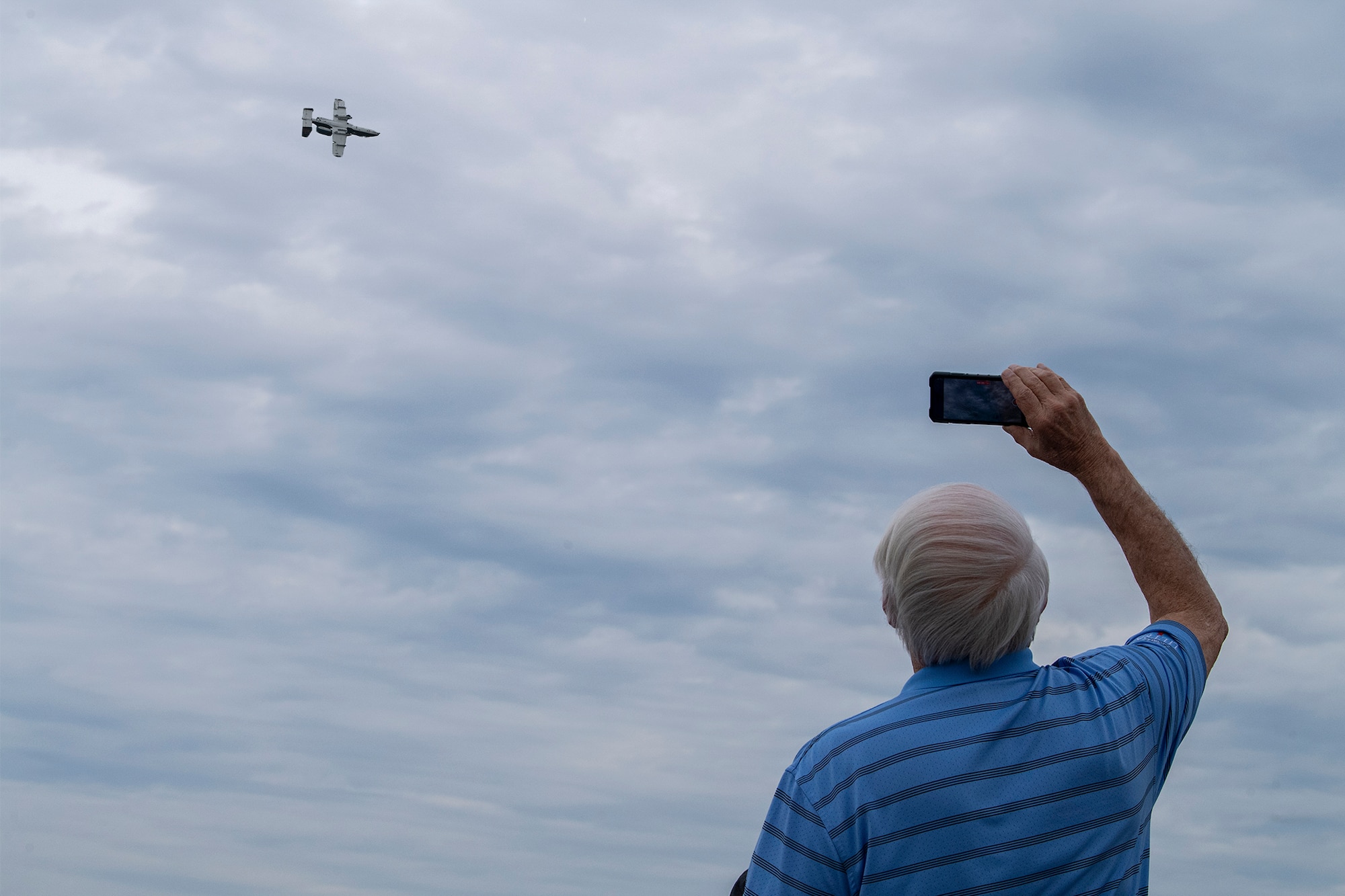 An attendee films an A-10 flying overhead