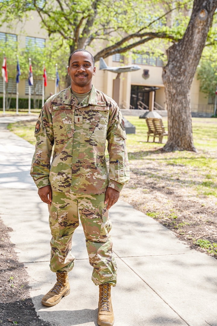Male Airman stands in front of building in U.S. Air Force uniform.