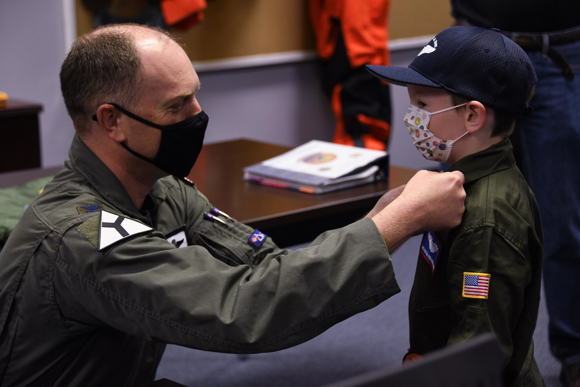 pilot puts on rank on kid's flight suit