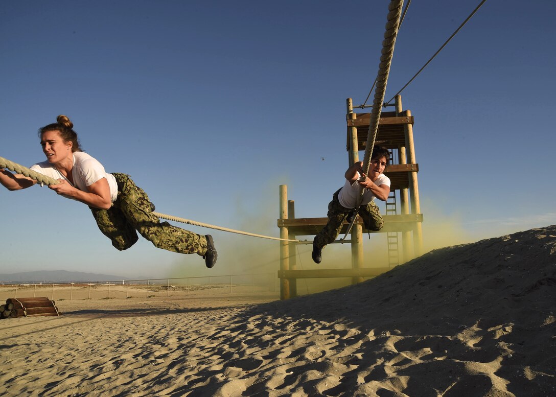 High-performance athletes Heather Hippensteel (left) and Lauren Fisher traverse an obstacle during Naval Special Warfare�s (NSW) Insert Challenge at Naval Special Warfare Center (NSWCEN).