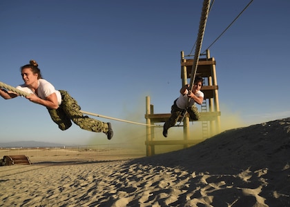 High-performance athletes Heather Hippensteel (left) and Lauren Fisher traverse an obstacle during Naval Special Warfare�s (NSW) Insert Challenge at Naval Special Warfare Center (NSWCEN).