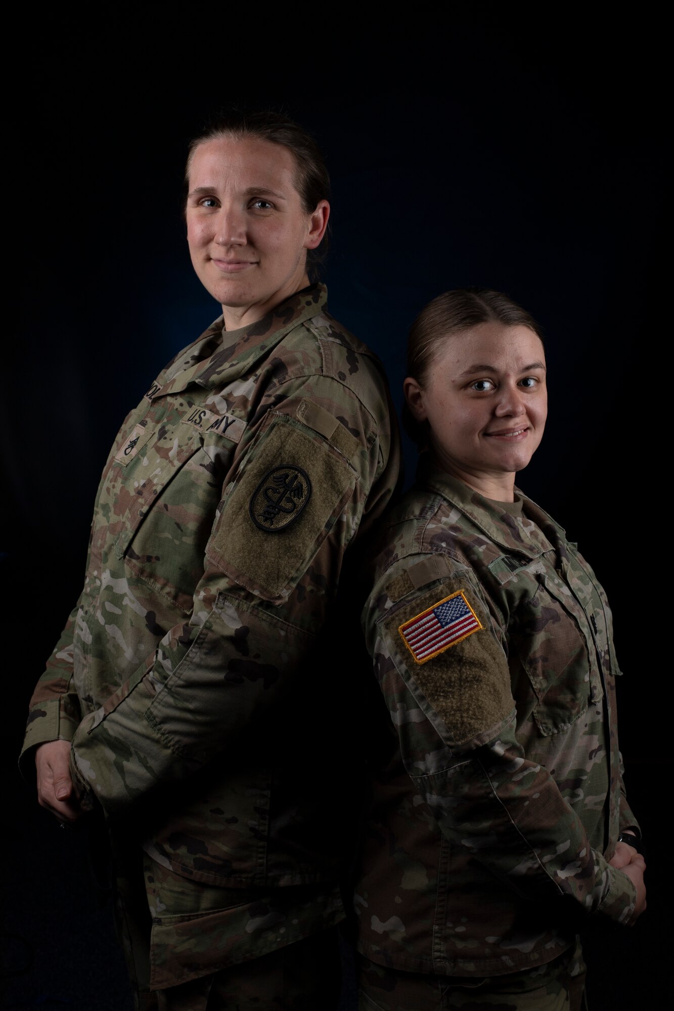 Two U.S. Army service women standing back to back
