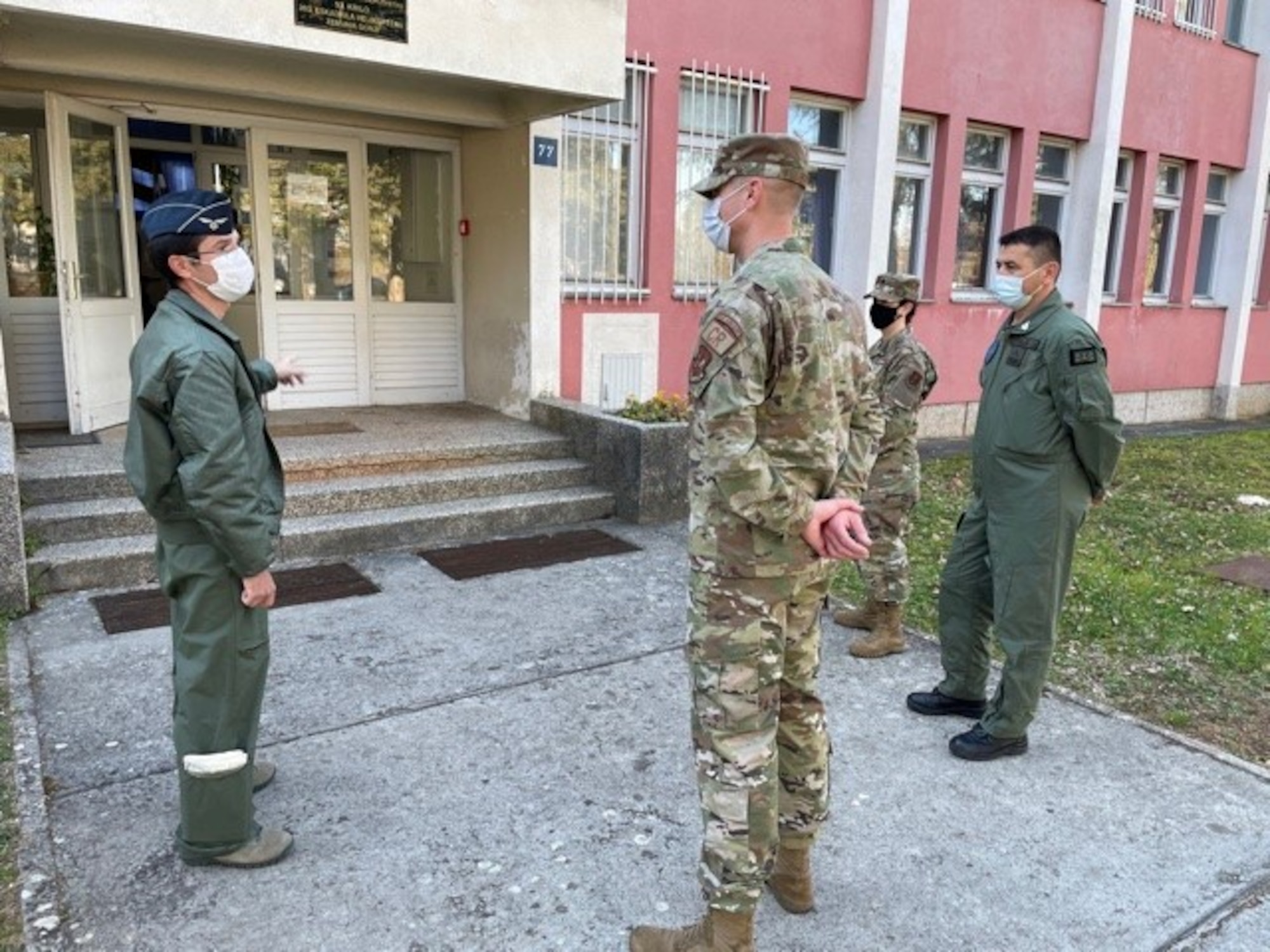 People stand outside a building talking to eachother.