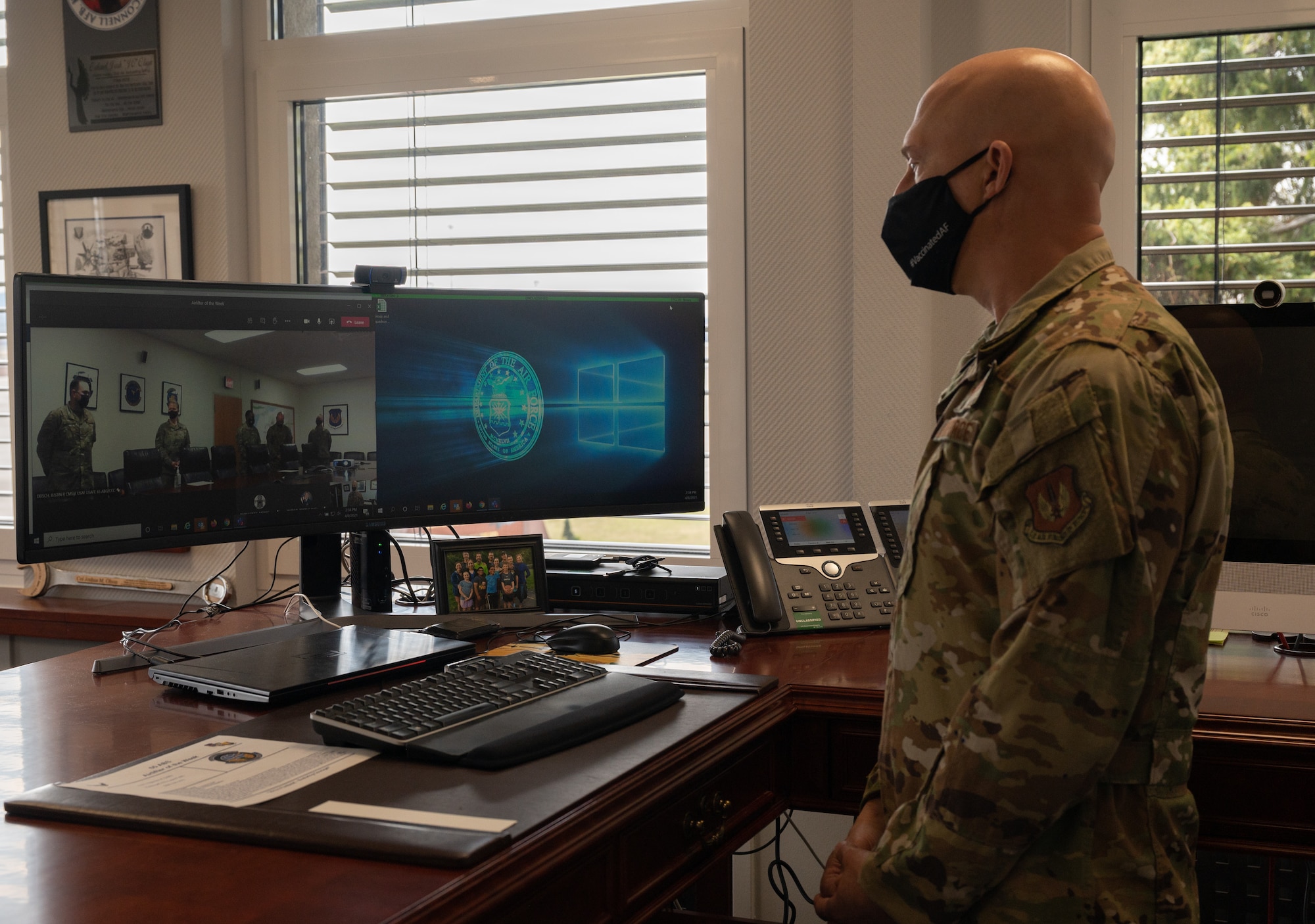 A commander standing at his desk.
