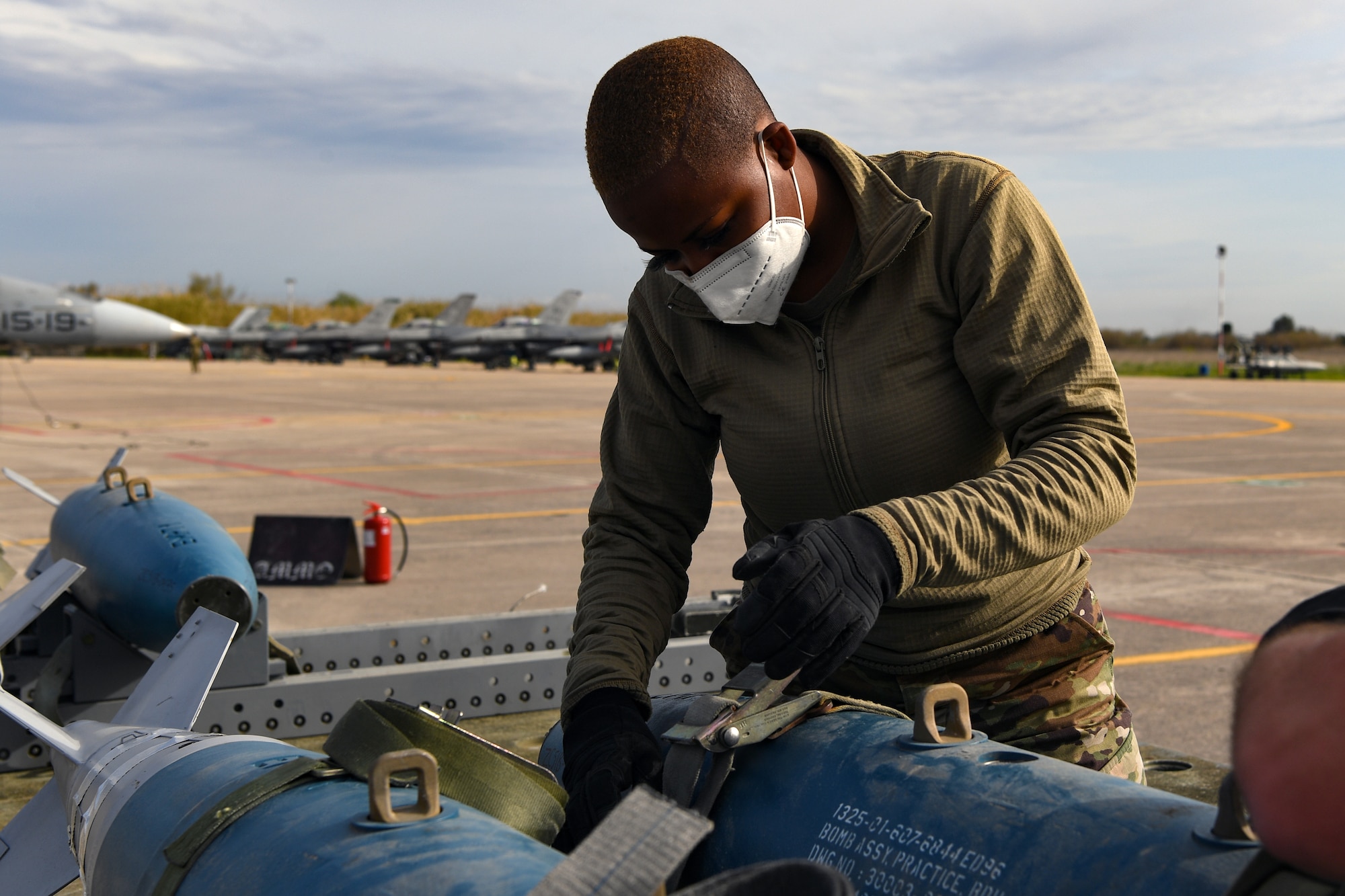 Senior Airman Sydney Williams, 31st Munitions Squadron (MUNS) line delivery crew chief, secures an inert bomb onto a trailer at Andravida Air Base, Greece, April 13, 2021. The 31st MUNS, along with other units from the 31st Fighter Wing, participated in INIOCHOS 21, a Hellenic air force-led, joint force exercise. (U.S. Air Force photo by Airman 1st Class Thomas S. Keisler IV)