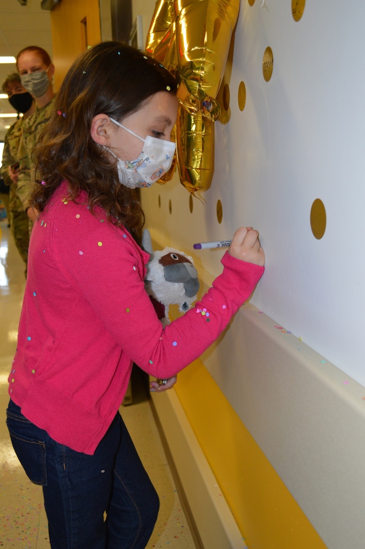 Seven-year-old Sailor Parker writes her name on a wall sticker