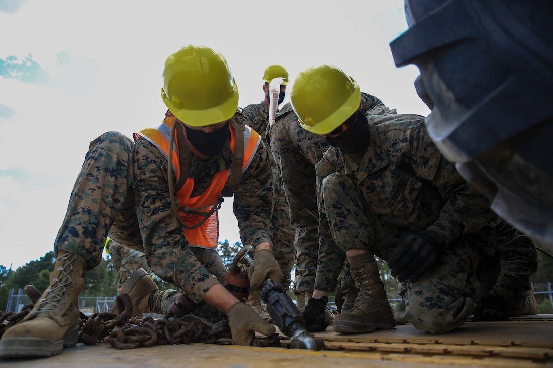 U.S. Marines with 2nd Marine Expeditionary Brigade, tie down a vehicle onto a rail car in preparation for Operational Logistics Exercise on Marine Corps Base Camp Lejeune, N.C., April 13, 2021. During OPLOGEX, U.S. Navy and Marine Corps forces will transport material and equipment on rail and ship and conduct pier-side offload of the USNS Williams at Blount Island command, Florida.
