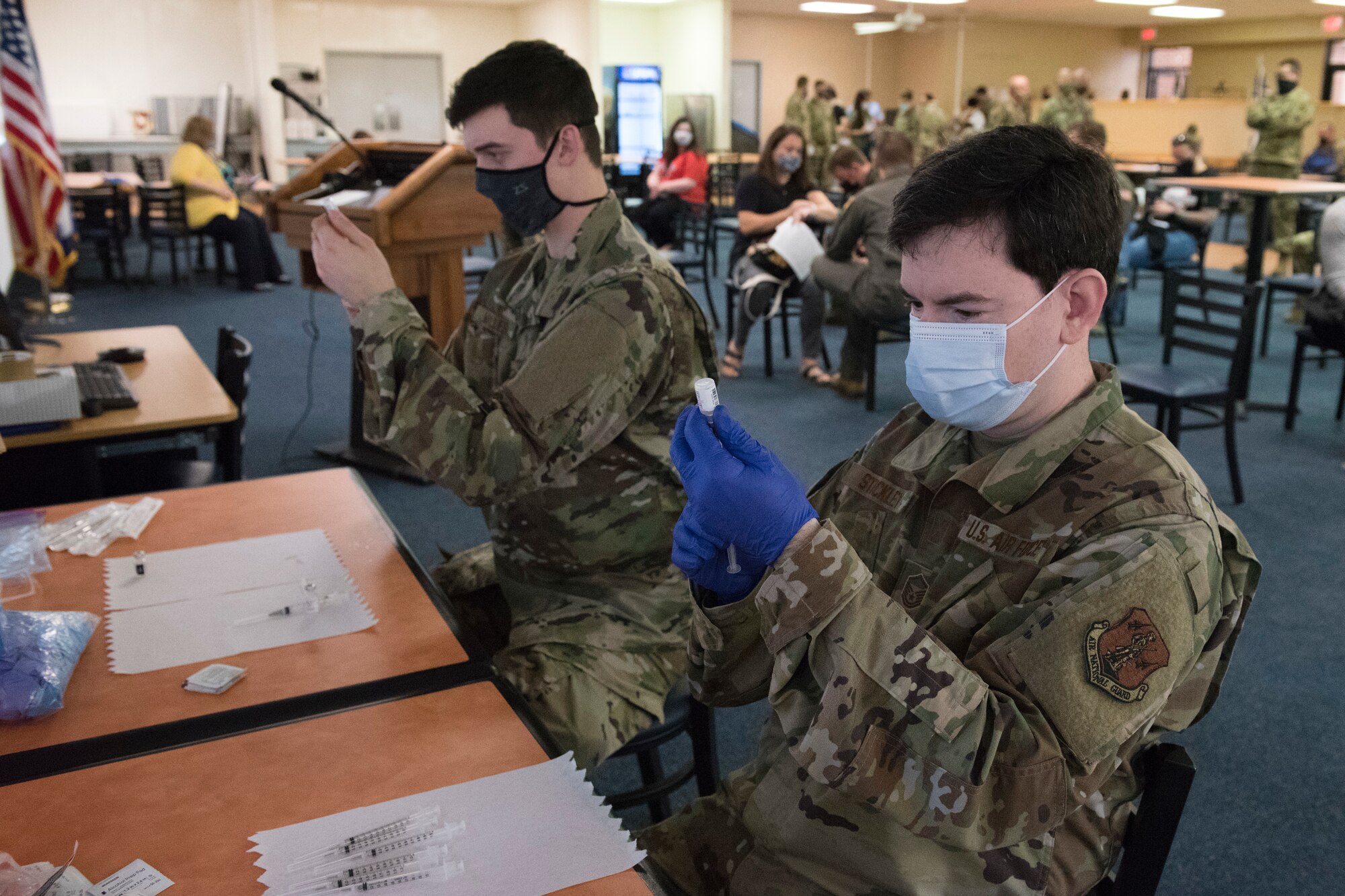 U.S. Air Force Staff Sgt. Ian Miller and Master Sgt. Matthew Stickley, aerospace medical technicians with the 167th Medical Group, currently assigned to the West Virginia National Guard’s Task Force Medical – East, prepare Pfizer COVID-19 vaccinations for military members and families in the 167th Airlift Wing dining facility, Martinsburg, West Virginia, Apr. 11, 2021.