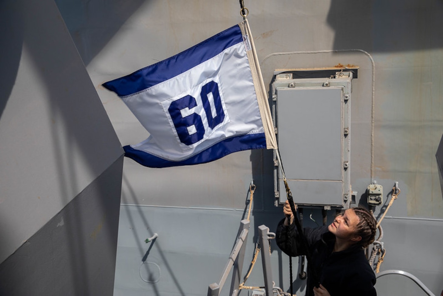 210415-N-CJ510-0159 MEDITERRANEAN SEA (April 15, 2021) Quartermaster Seaman Caityln Menze raises the Destroyer Squadron 60 pennant aboard the Arleigh Burke-class guided-missile destroyer USS Roosevelt (DDG 80), April 15, 2021. Roosevelt, forward-deployed to Rota, Spain, is on its second patrol in the U.S. Sixth Fleet area of operations in support of regional allies and partners and U.S. national security interests in Europe and Africa. (U.S. Navy photo by Mass Communication Specialist 2nd Class Andrea Rumple/Released)