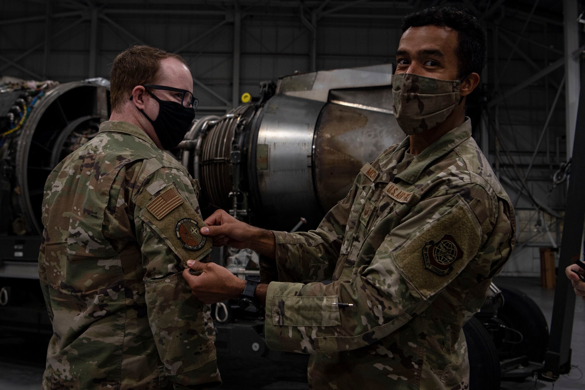 Photo of Airmen putting on a squadron patch.