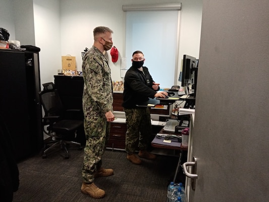 Lt. Cmdr. Joshua Turner, public works officer and security officer for Naval Support Facility (NSF) Redzikowo, talks with Chief Master-at-Arms Zane Kentner in Kentner's office.