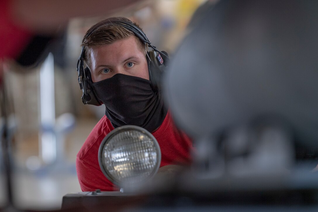 Photo of an Airman assisting with a munitions load
