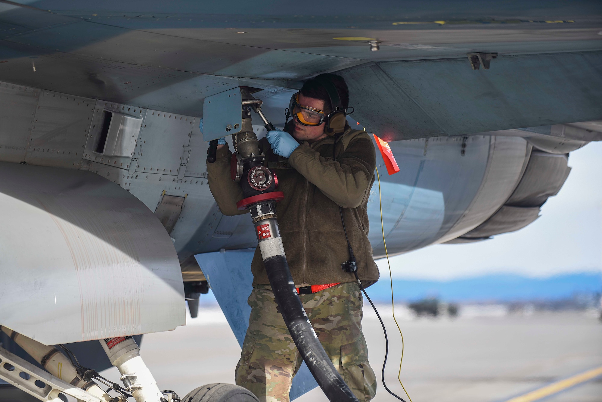 Senior Airman Shane Weber, 18th Aggressors Squadron avionics technician, refuels an F-16 Fighting Falcon, April 13, 2021, on Eielson Air Force Base, Alaska. Airmen trained during Arctic Gold 21-2 to accomplish multiple duties on the flightline, making our force more flexible during rapid deployment operations. (U.S. Air Force photo by Senior Airman Keith Holcomb)