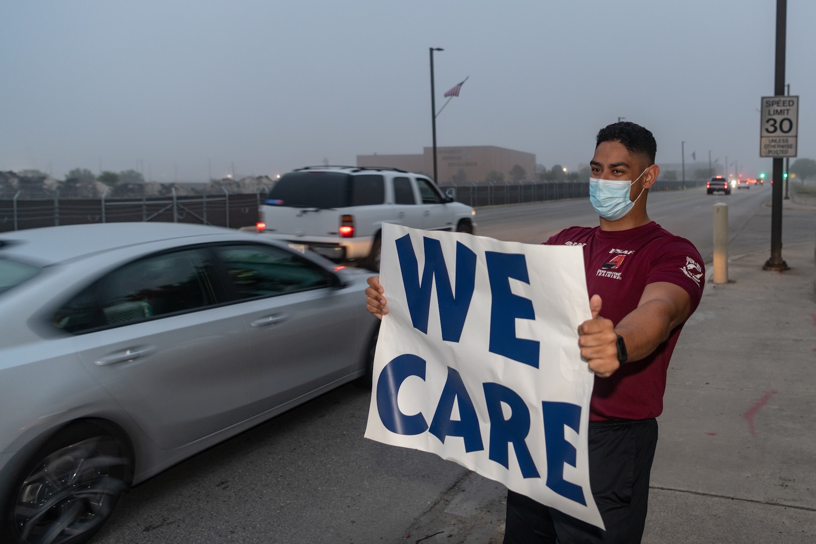 U.S. Air Force Capt. John Red, flight commander of the 323rd Training Squadron, greets cars during the We Care Day event, April 16th, 2021, at Joint Base San Antonio-Lackland, Texas.