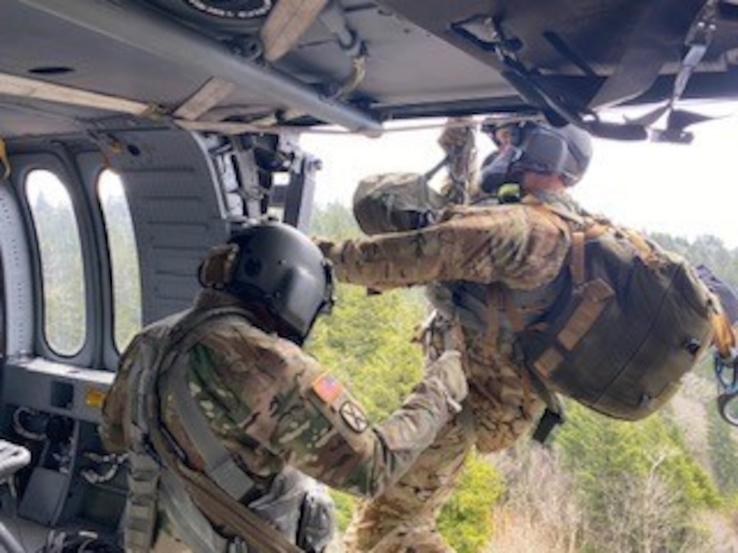 Tennessee National Guard Sgt. 1st Class Tracy Banta begins hoist operations, descending from a Black Hawk helicopter to a stroke victim who was hiking on the Appalachian Trail in Great Smoky Mountains National Park April 15, 2021. The patient was flown to a hospital in Knoxville.