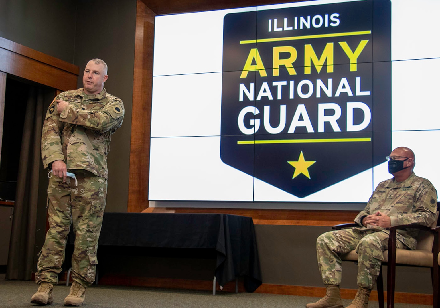 Newly promoted Lt. Col. Michael Barton, of Greenview, Illinois, points to the United States flag on his uniform to illustrate each member of the Illinois National Guard is an ambassador regardless of their reason for serving.