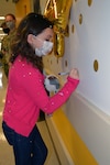 Seven-year-old Sailor Parker writes her name on a wall sticker after she rang the bell in the Brooke Army Medical Center Pediatric Hematology/Oncology Clinic April 1, signifying she won her battle against Acute Lymphocytic Leukemia.