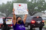 Volunteers hold signs in support of the We Care Day event April. 16, 2021, at Joint Base San Antonio-Randolph, Texas. The event was in support of Month of the Military Child and Child Abuse awareness month.