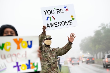 Command Master Chief Wendell Snider (middle) holds a signs in support of the We Care Day event April. 16, 2021, at Joint Base San Antonio-Randolph, Texas. The event was in support of Month of the Military Child and Child Abuse awareness month.