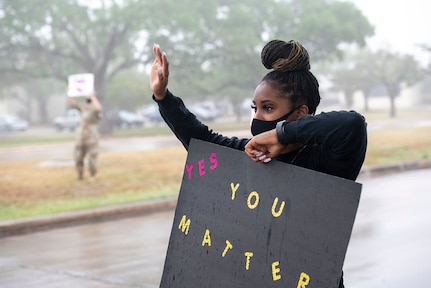 Tech Sgt. Alacia Hatten holds a sign in support of the We Care Day event April. 16, 2021, at Joint Base San Antonio-Randolph, Texas. The event was in support of Month of the Military Child and Child Abuse awareness month. (U.S. Air Force photo by Sabrina Fine)